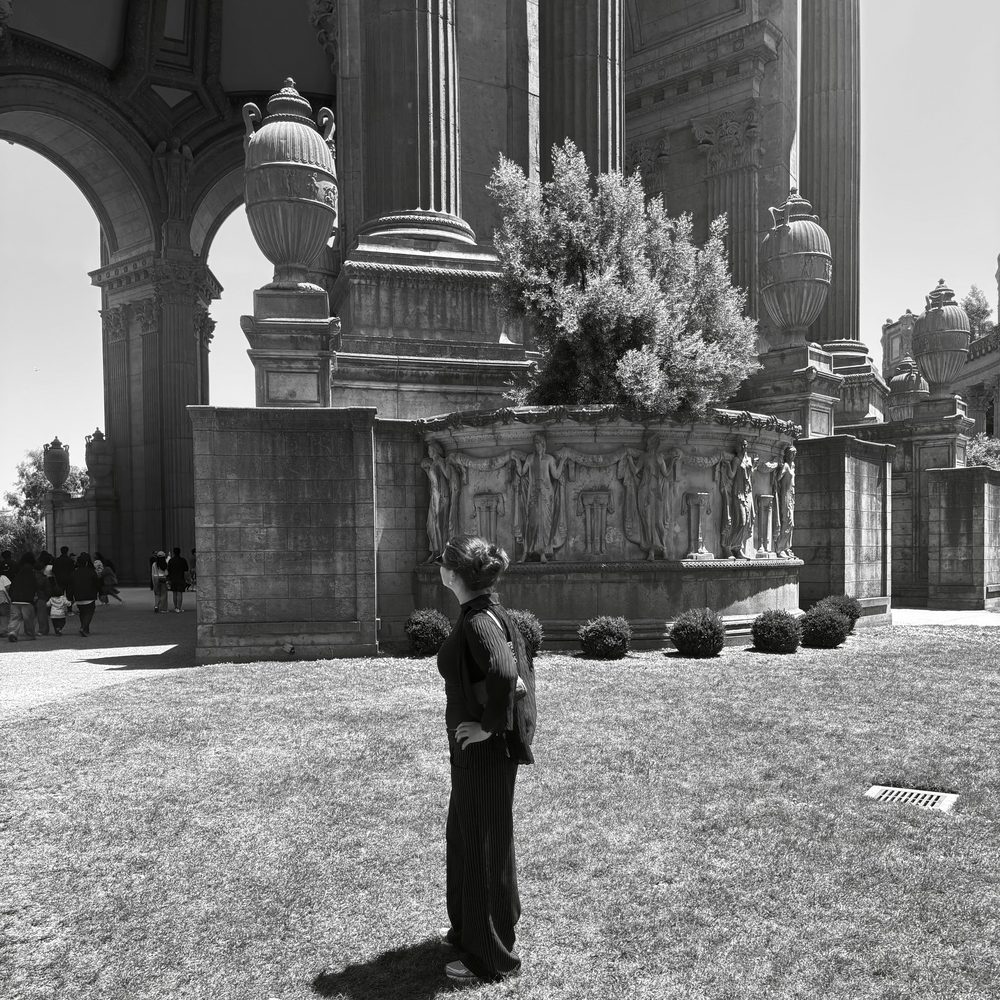 Jaden standing with her hand on her hip in front of tall stone columns and statues